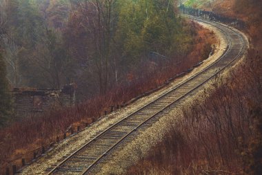 Kanada sonbahar manzarasında tren yolu. Aşağıdaki küçük tuğla evin kalıntıları. Ontario, Kanada.