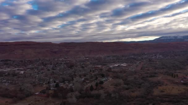 Moab City και απομακρυσμένα βουνά για το πρωί συννεφιά. Γιούτα, ΗΠΑ. Αεροφωτογραφία — Αρχείο Βίντεο