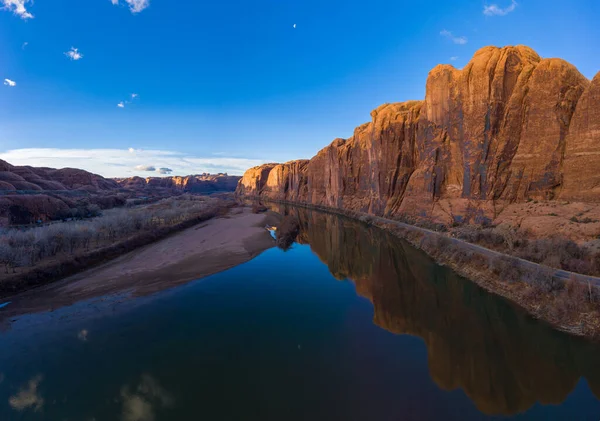 Rzeka Kolorado i klify Red Sandstone w słoneczny dzień. Obszar wspinaczkowy Wall Street. Błękitne niebo odbicie w wodzie. Grand County, Utah, USA. Widok z powietrza — Zdjęcie stockowe