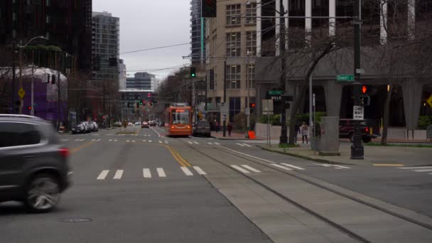 シアトル、米国- 2021年2月4日:トラム、道路、マスクを身に着けている人々と都市景観 — ストック動画