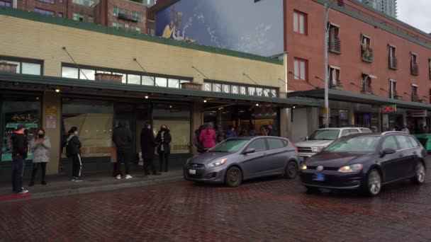 SEATTLE, USA - 4. FEBRUAR 2021: Maskierte stehen auf dem Bürgersteig und warten darauf, ein Starbucks zu betreten — Stockvideo