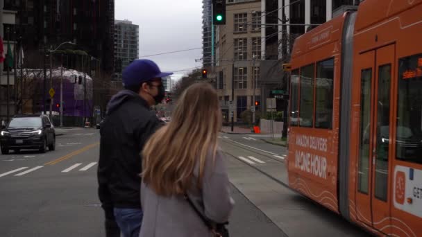 SEATTLE, USA - FEBRUARI 4, 2021: Tram, Road, mensen met maskers en stadsgezicht — Stockvideo