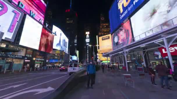 NOWOŚĆ YORK CITY, USA - STYCZEŃ 23, 2021: Samotny człowiek noszący maskę i korzystający ze smartfona stojącego nieruchomo na Times Square w nocy podczas pandemii koronawirusowej. Samochody i ludzie. Czas ucieka. — Wideo stockowe
