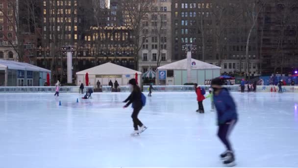 NOWOŚĆ YORK CITY, USA - STYCZEŃ 23, 2021: Ludzie noszący maski Jazda na łyżwach na lodowisku w parku Bryant na Manhattanie w zimowy dzień — Wideo stockowe