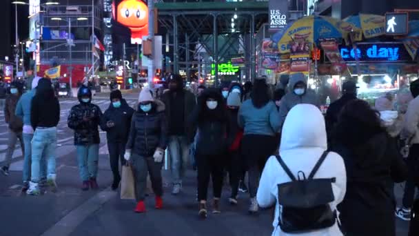 NEW YORK CITY, USA - 23 gennaio 2021: Le persone indossano maschere che attraversano una strada a Times Square di notte. Midtown Manhattan — Video Stock