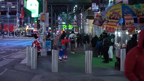 NOVA IORQUE CIDADE, EUA - JANEIRO 23, 2021: Pessoas vestindo máscaras Atravessando uma rua na Times Square à noite. Midtown Manhattan — Vídeo de Stock