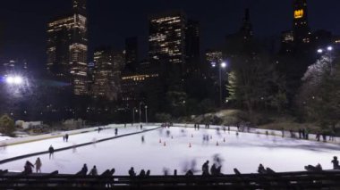 İnsanlar akşam saatlerinde Central Park 'ta buz pateni pistinde buz pateni yapıyorlar. New York Şehri