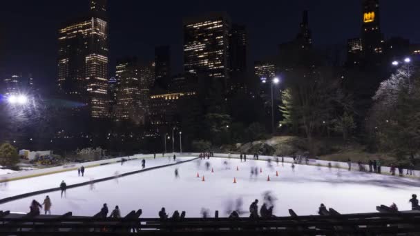 Az emberek korcsolyáznak a jégpályán a Central Parkban esténként. New York város — Stock videók