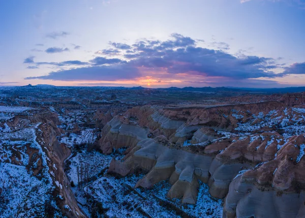 Kappadokien im Winter bei Sonnenuntergang. Schneebedeckte Hügel und Säulen. Türkei. Luftaufnahme. — Stockfoto