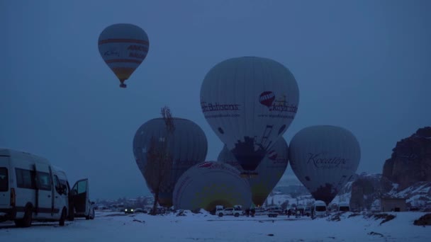 CAPPADOCIA, TURKEY - APRIL 10, 2021: Hot-air balloons are Taking Off in Snowy Cappadocia in Winter Morning. 터키 — 비디오