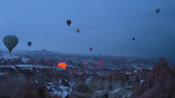 CAPPADOCIA, TURKEY - 10 Nisan 2021: Kış Sabahı Alacakaranlığı 'nda Kapadokya' da sıcak hava balonları. Hindi. Hava görüntüsü. Drone İleri Uçuyor — Stok video