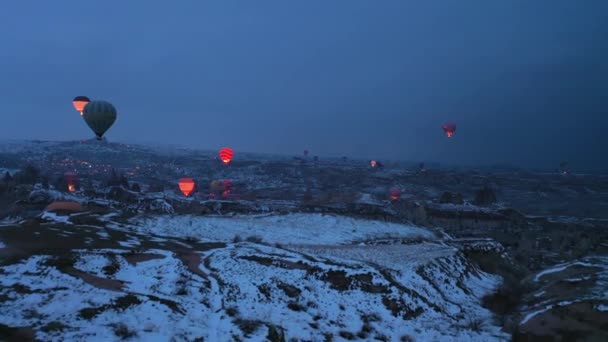 CAPPADOCIA, TURCHIA - 10 APRILE 2021: Palloncini ad aria calda in Cappadocia nel crepuscolo invernale del mattino. Tacchino. Vista aerea. Il drone vola in avanti — Video Stock