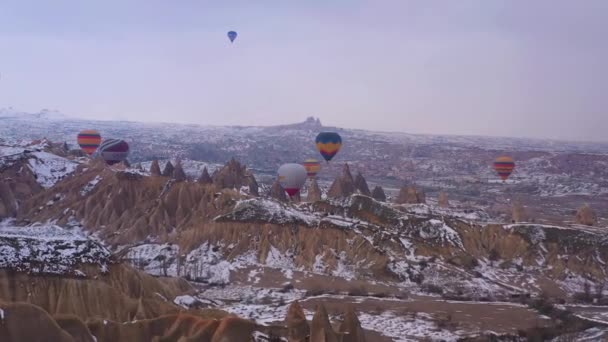 CAPPADOCIA, TURKEY - APRIL 10, 2021: повітряні кулі в сніжному каппадокії в зимовий ранок. Туреччина. Вид з повітря. Дрони йдуть уперед — стокове відео