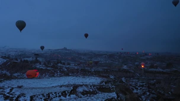 KAPPADOCIA, TÜRKEI - 10. APRIL 2021: Heißluftballons in Kappadokien in der Wintermorgendämmerung. Türkei. Luftaufnahme. Drohne fliegt seitlich — Stockvideo