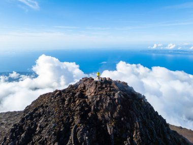 Sunny Day 'de bulutların üstündeki Pico Dağı' nın tepesindeki adam. Zirve ve ve Atlantik Okyanusu. Pico Adası, Azores. Portekiz. Hava Görünümü