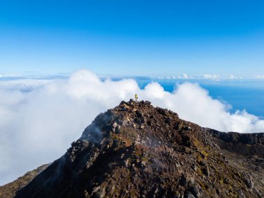 Güneşli bir günde Pico Dağı 'nın tepesinde yürüyüş yapan adam. Zirve ve ve Atlantik Okyanusu. Pico Adası, Azores. Portekiz. Hava Görünümü