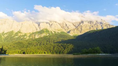 Eibsee Gölü, Ormanlı Dağ yamaçları ve Güneşli Akşamlarda Zugspitze Massif. Bavyera, Almanya. Zaman Süreleri