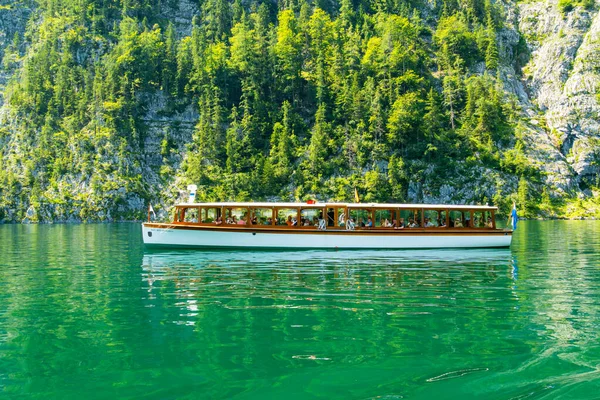 KONIGSSEE, Almanya - 15 Temmuz 2025: Konigssee Gölü ve Turistli Tekne. Yeşil Dağ yamacı. Bavyera, Almanya. Tekneden Görünüm
