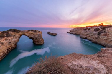 Albandeira Sahili yakınlarındaki Albandeira Kemeri. Akşam Alacakaranlığı 'nda uçurumlar ve Atlantik Okyanusu. Algarve, Portekiz