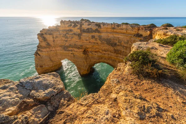 Heart Shaped Arch near Marinha Beach. Cliffs and Atlantic Ocean in Sunny Morning. Golden Hour. Algarve, Portugal