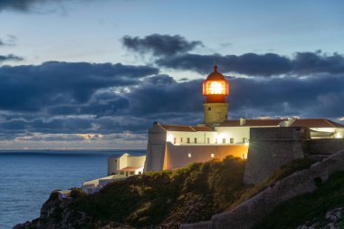 Akşam Alacakaranlığı 'nda, Cliff ve Atlantik Okyanusu' ndaki Ponta da Piedade Deniz Feneri 'ni aydınlattı. Mavi Saat. Algarve, Portekiz