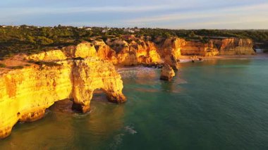 Marinha Sahili, Kemer, Deniz Yığını, Kayalıklar ve Güneşli Sabah Atlantik Okyanusu. Altın Saat. İHA atışı. Algarve, Portekiz. Yörüngede