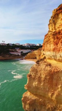 Güneşli bir günde Benagil Sahili, Kayalıklar ve Atlantik Okyanusu. İHA atışı. Algarve, Portekiz. İlerleme kaydediyoruz. Dikey Video