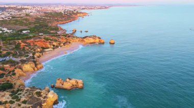 Güneşli bir günde Paradinha Sahili, Burunlar, Kayalıklar, sahil şeridi ve Atlantik Okyanusu. Yeşil Ağaçlar. Hava görüntüsü. Algarve, Portekiz. Geriye Taşıma