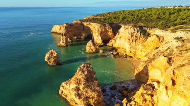 Marinha Sahili, Kemer, Deniz Yığını, Altın Kayalıklar ve Güneşli Sabah Atlantik Okyanusu. Yeşil çalılık. Hava görüntüsü. Algarve, Portekiz. İleriye Taşınma