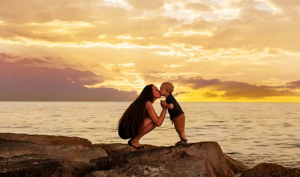 Mãe e bebê na praia após o pôr do sol — Fotografia de Stock