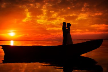 Silhouette of couple kissing in sunset clipart