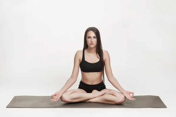 Femme méditant sur tapis de yoga — Photo