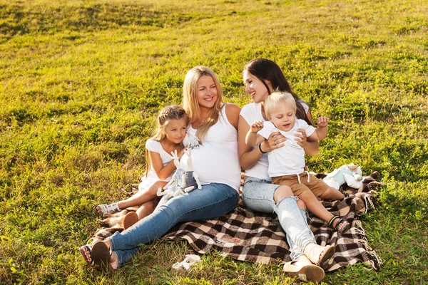 Two friends with kids laughing outdoors — Stock Photo, Image