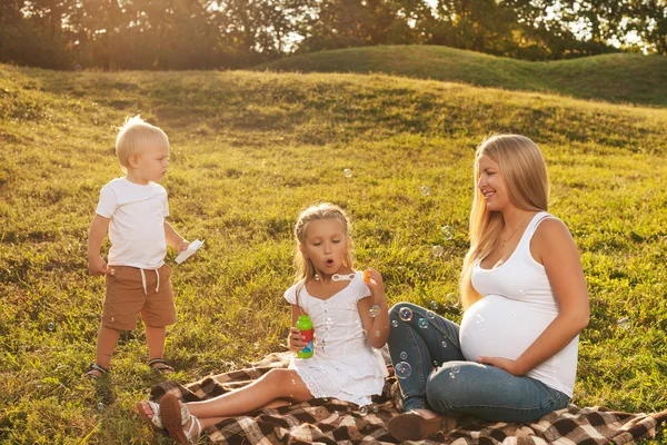 Zwangere vrouw met haar kinderen — Stockfoto