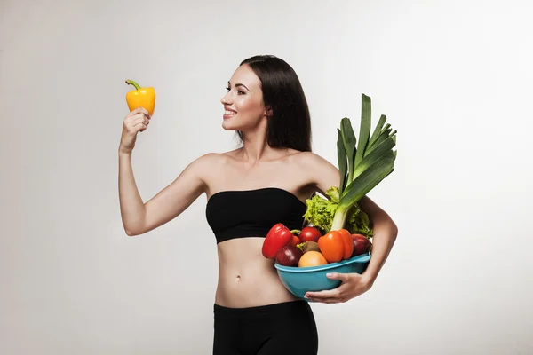Portrait of young fit woman holding vegetables — Stock Photo, Image