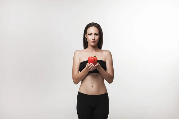 Portrait de jeune femme en forme tenant poivron — Photo