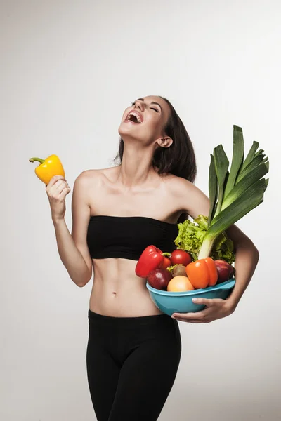 Portrait of young fit woman holding vegetables — Stock Photo, Image