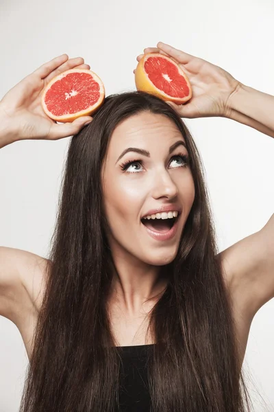 Забавный образ молодой женщины, держащей грейпфрут — стоковое фото