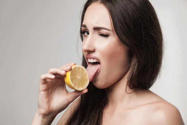 Immagine divertente di una giovane donna che mangia limone — Foto Stock