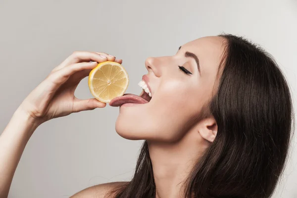 Портрет молодой женщины, поедающей лимон — стоковое фото