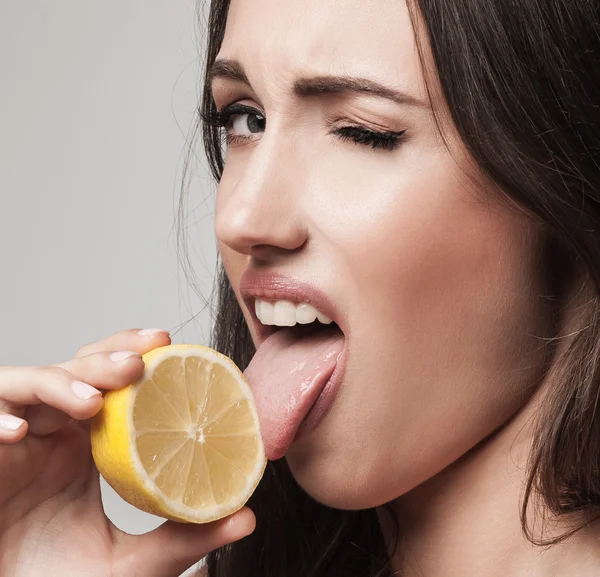 レモンを食べる若い女性の肖像画を間近します。 — ストック写真