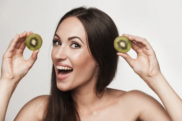 Retrato engraçado de mulher jovem segurando kiwis — Fotografia de Stock