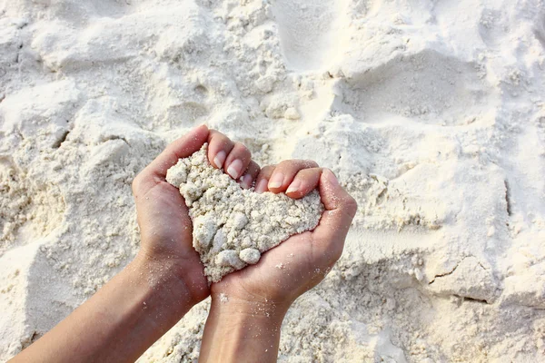 Gros plan mains tenant sable blanc forme de coeur — Photo