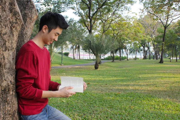 Jonge man aan het lezen in het park — Stockfoto