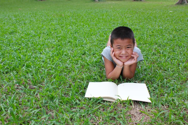 Jeune garçon lisant dans le parc — Photo