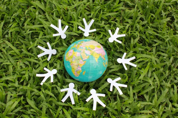 Paper people in a circle with green grass background — Stock Photo, Image