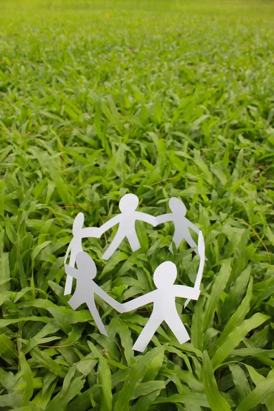 Gente de papel en un círculo con fondo de hierba verde — Foto de Stock