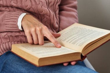 Oturan ve kitap okuyan bir kadın. Rahatlatıcı kavram
