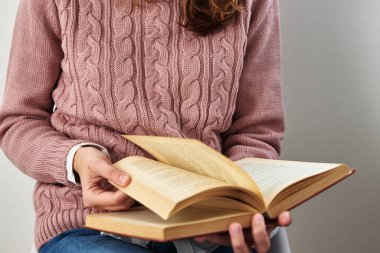 Oturan ve kitap okuyan bir kadın. Rahatlatıcı kavram