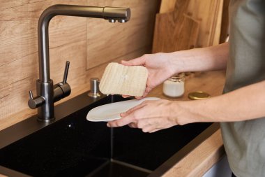 Kadın bulaşıkları organik çevre dostu süngerle yıkıyor. Sıfır atık